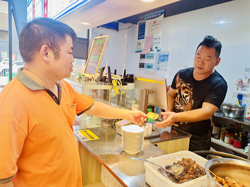 快递员凭积点券在“红色之家”餐馆兑换一碗热米粉。