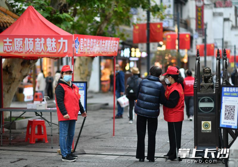 太平街口，社区志愿者有序引导游客扫码进场。