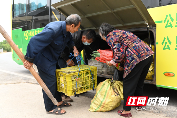 安仁县渡口乡长滩村村民搭乘客货邮融合公交车进县城卖菜。.jpg