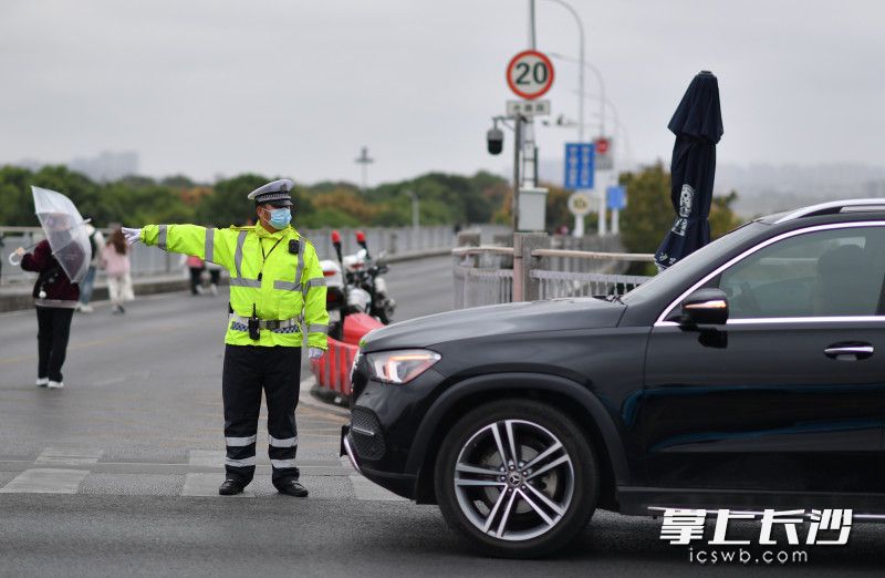 橘子洲大桥上，一位交警正在疏导交通。