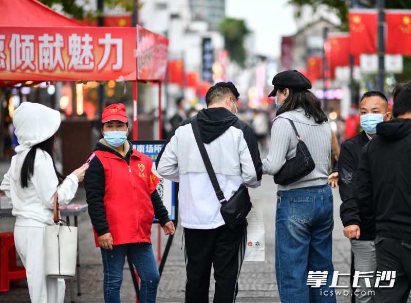 太平街口，社区志愿者有序引导游客扫码进场。