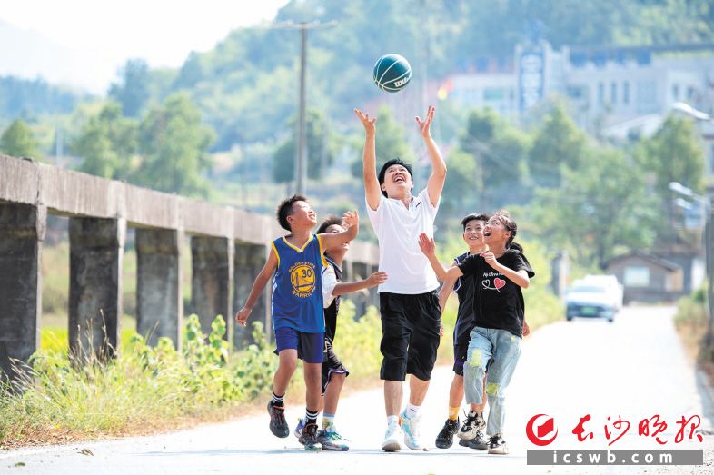 　　王诗果和孩子们在乡间小道上练习抢球。长沙晚报全媒体记者 郭雨滴 摄