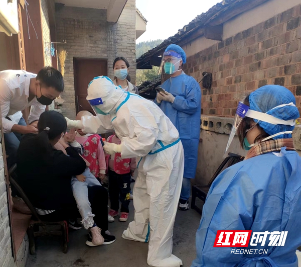 协助医护人员上门为居家隔离人员做核酸检测。.jpg