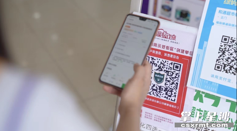 在长沙县福临镇信用示范街区，市民可扫码查看商户的信用数据。县发改局供图