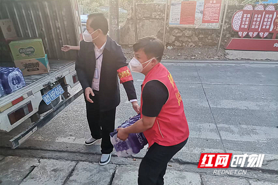 志愿者曾翔在徐家井社区帮助社区工作人员装卸物资.jpg