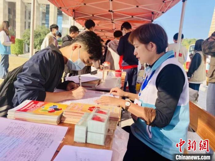 活动现场，漳州市红十字会志愿者指导同学填写中国造血干细胞捐献志愿者信息表。　受访者供图