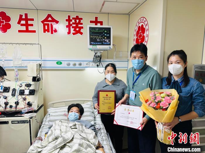 杜颖鑫(左一)及家人与福建省红十字会工作人员合影。　薛昀 摄