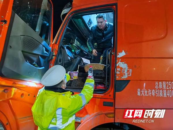 图六：常德津市市公安局交警大队民警给因雨雪天气滞留高速出口的货车司机送温暖.jpg