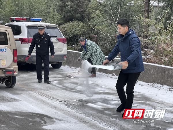 图四：常德石门县公安局交警大队联合乡政府在冰雪湿滑路段撒盐融冰除雪.jpg