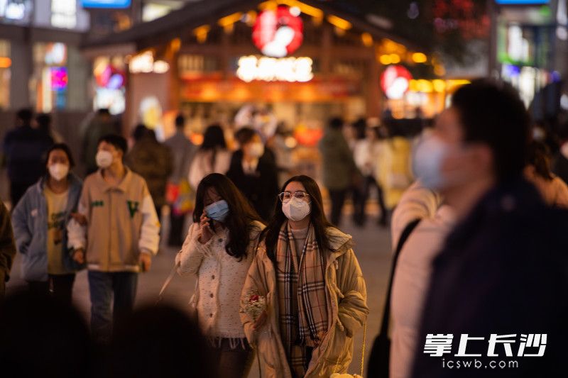 在黄兴南路步行街，市民游客在夜色中出行游玩。