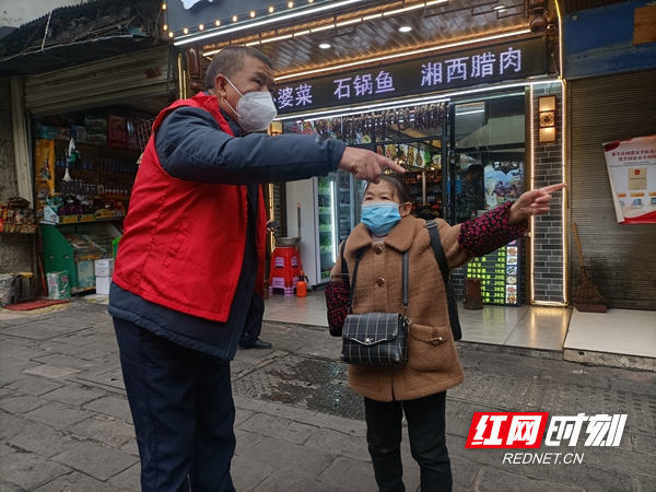 身穿红马甲党员志愿者在给市民指路。.jpg
