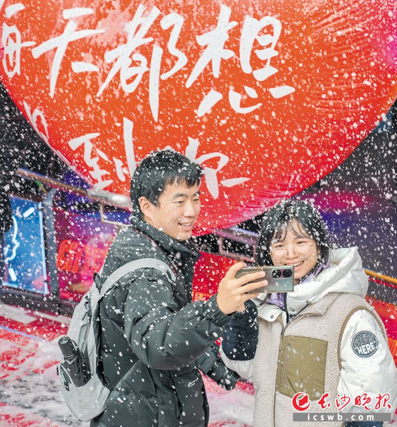 　　商场外，市民在商家制造的“雪花”里拍照留念。长沙晚报全媒体记者 陈飞 摄