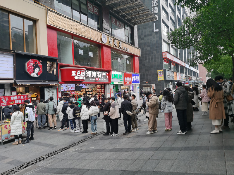 奶茶等小吃店前排起的长队。