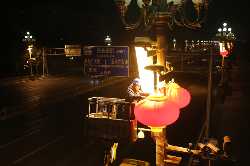 北京电力城市照明管理中心华灯班成员在长安街华灯上调试新安装的大红灯笼。魏晓彬摄 北京电力城市照明管理中心华灯班成员在长安街华灯上调试新安装的大红灯笼。魏晓彬摄