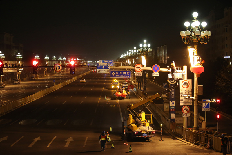 北京电力城市照明管理中心工作人员正在长安街华灯设备上安装大红灯笼。魏晓彬摄 北京电力城市照明管理中心工作人员正在长安街华灯设备上安装大红灯笼。魏晓彬摄