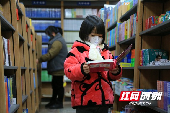 1月15日，春节临近，湖南省靖州苗族侗族自治县的某书店内，一位小女孩站在书架前认真地阅读。易子明+摄+(2).marked.jpg