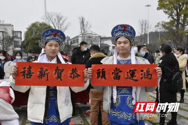 参与传统文化表演的工作人员举着“恭贺新年”“鸿运当头”的对联横批.jpg