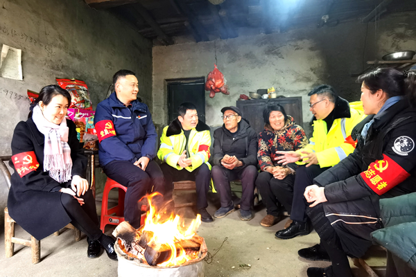 湘潭分公司党员志愿者与走访慰问群众围着炉火闲话家常.png
