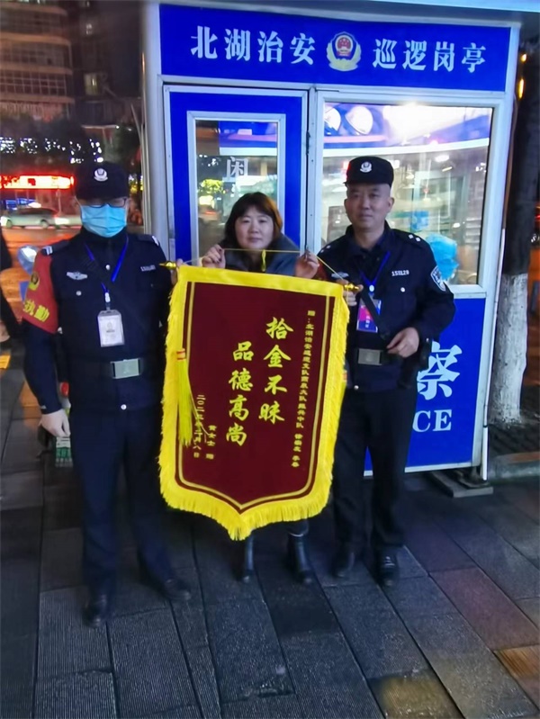 图二黄女士将一面印着“拾金不昧·品德高尚”的锦旗送到燕泉治安巡逻大队振兴中队徐宗友、李春手中。.jpg