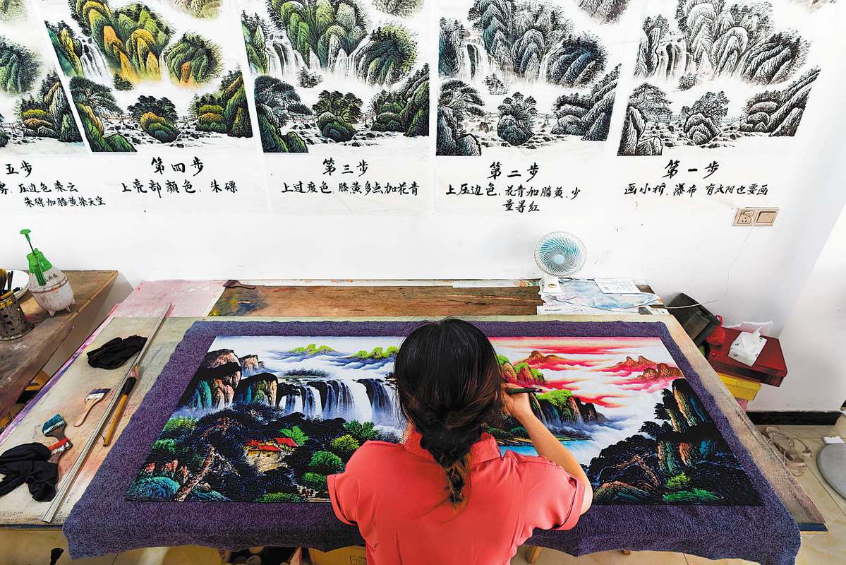 A farmer paints at a studio in Xiaohe town of Liuyang, Hunan province, last year. CHINA DAILY