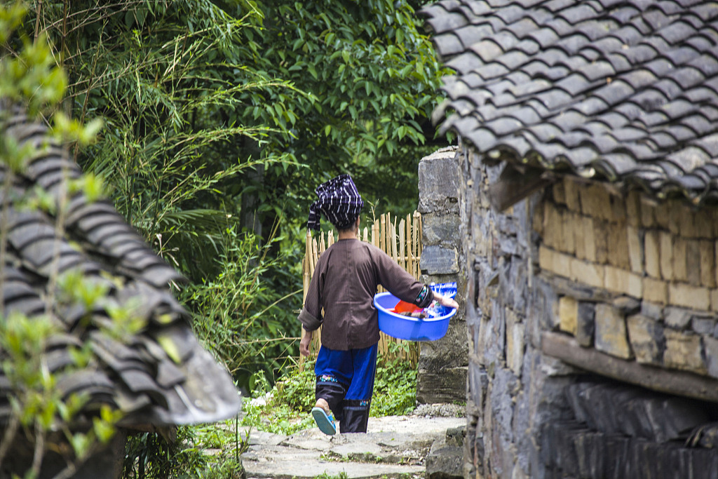 A woman from the Miao ethnic group undertakes some village chores. /CFP