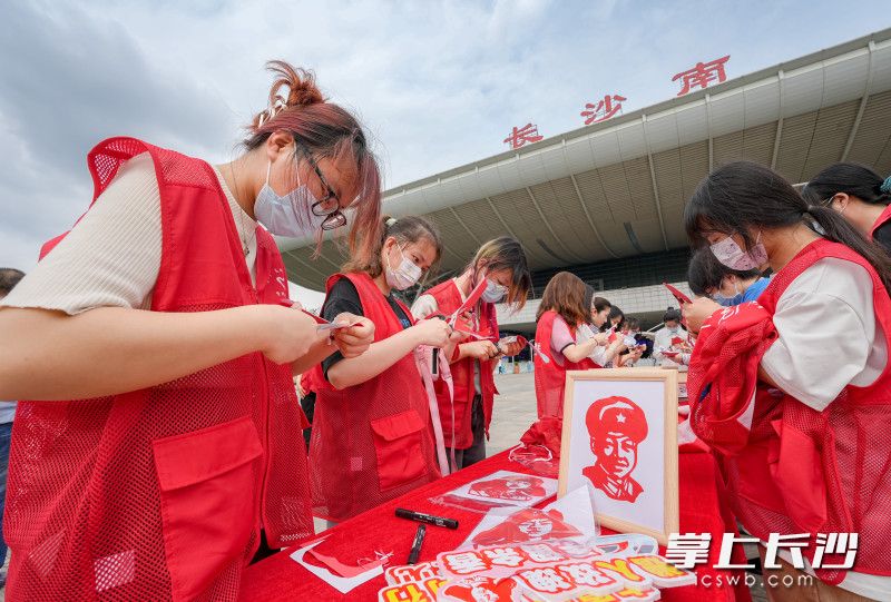 志愿者们纷纷用剪刀和红纸剪出雷锋头像。 均为全媒体记者 陈飞 摄