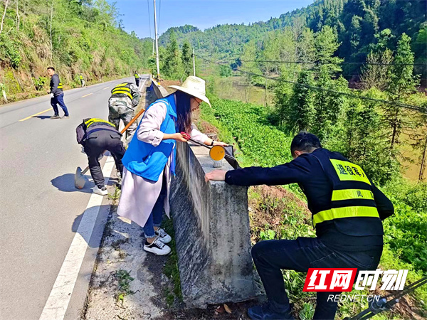志愿者们对公路两侧、杂草丛中的废弃物、纸屑、烟头等白色垃圾进行清理。.jpg