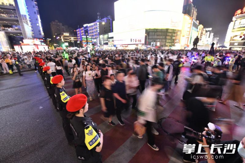 在解放路黄兴路口，特警们组成“人墙”，守护市民游客通行。