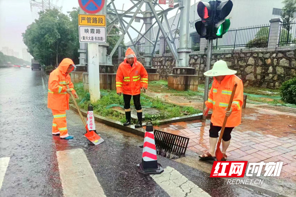 市政工人在映霞路与东七线路口处理积水问题。.jpg