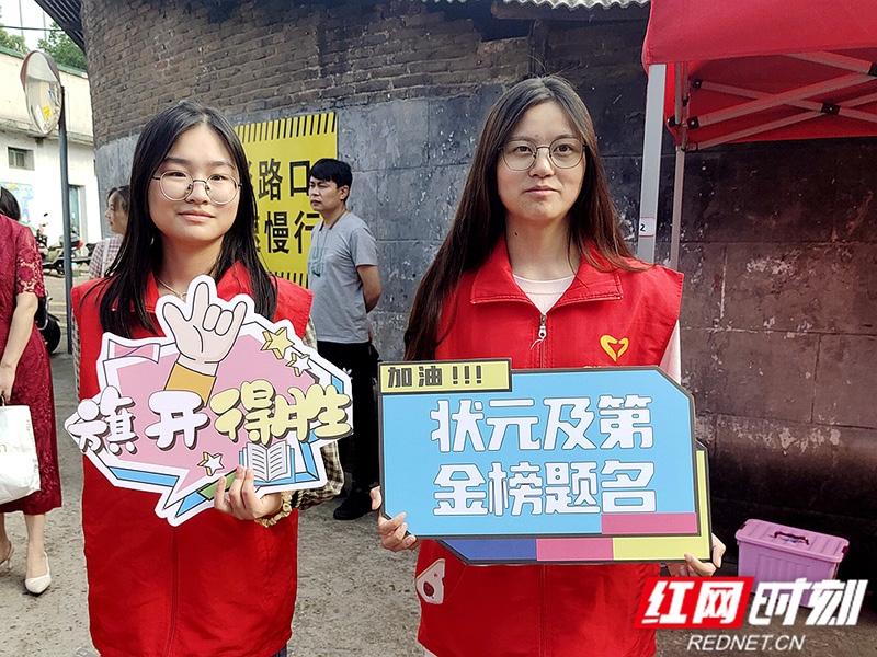 湘潭市三中考点外，志愿者举着有加油口号的标语牌为考生送上祝福.jpg