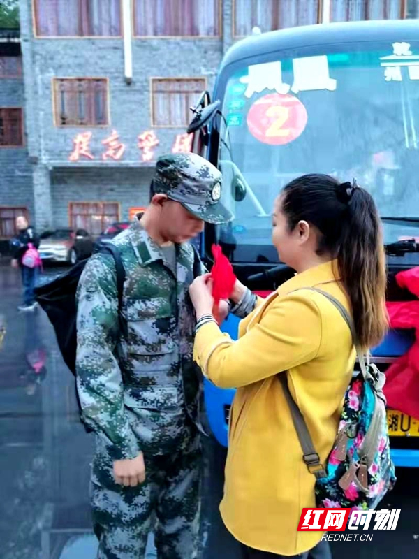 彭兰秀给吴某合戴上光荣入伍的大红花。.jpg