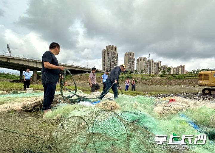 现场，专业施工人员正在对违规渔具钓具等进行拆解销毁。