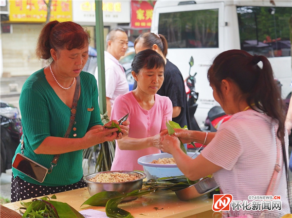 比赛开始,大家不慌不忙包起粽子来,只见大家手指飞舞,很快就包好一个粽子。