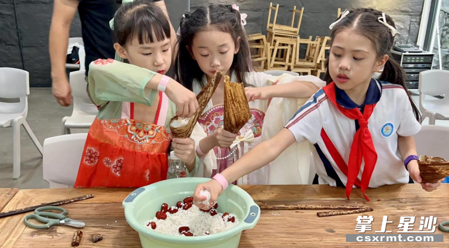 青山铺镇天华山景区，孩子们正认真学习包粽子。青山铺镇供图