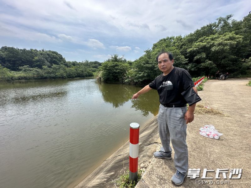 事发池塘边，65岁的范春泉回忆胡光跃舍己救人的场景。  均为长沙晚报全媒体记者刘琦摄