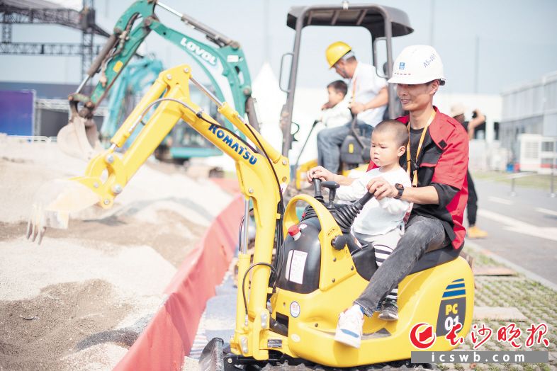 5月14日，第三届长沙国际工程机械展览会现场，许多家长带着孩子来体验开挖机的快乐。
