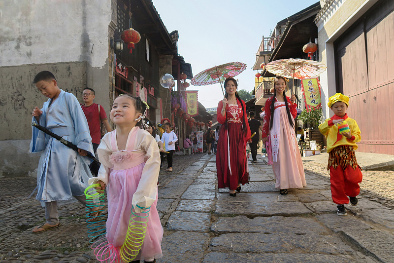 Visitors dressed in traditional Chinese clothing walk along on Liuzi Street, Yongzhou City, Hunan Province. /CFP