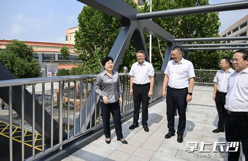 吴桂英在天心区仰天湖实验学校外，调研城区学校人行天桥项目建设情况。