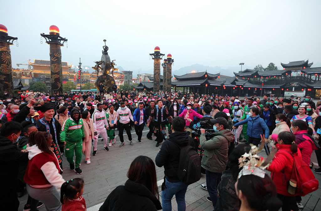 This file photo shows visitors experiencing a local intangible cultural heritage project during their stay in Zhangjiajie, Hunan Province. /CFP