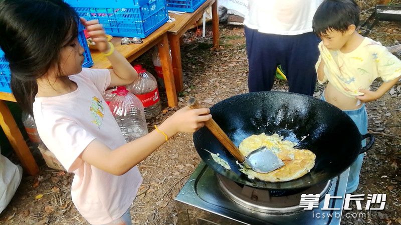 小女孩在炒菜。