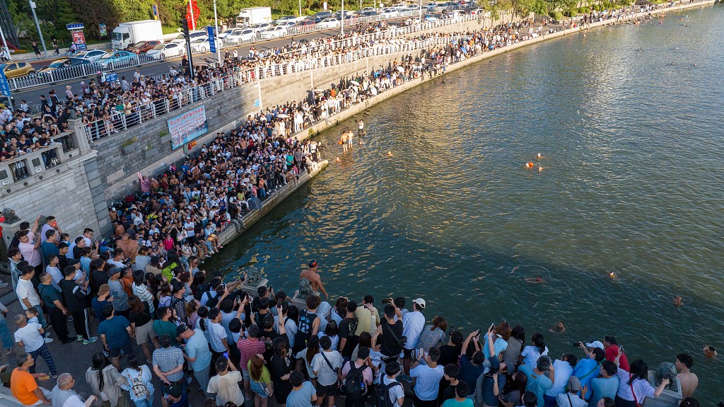 A photo taken on August 28, 2023, shows a man diving into the Haihe River in front of crowds of onlookers in Tianjin, China. /CFP