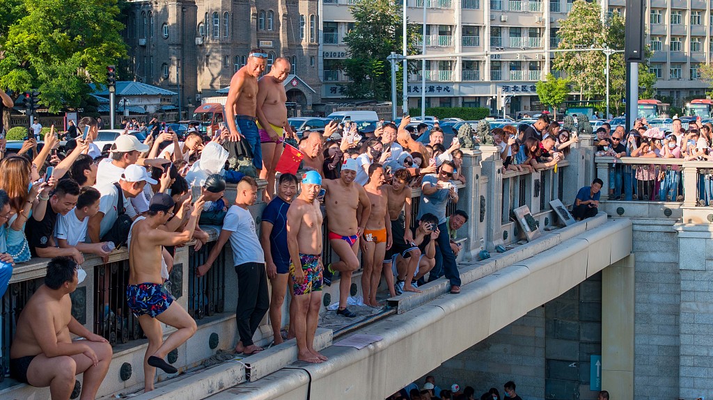 A photo taken on August 28, 2023, elderly men ready to dive into the Haihe River in front of crowds of onlookers in Tianjin, China. /CFP