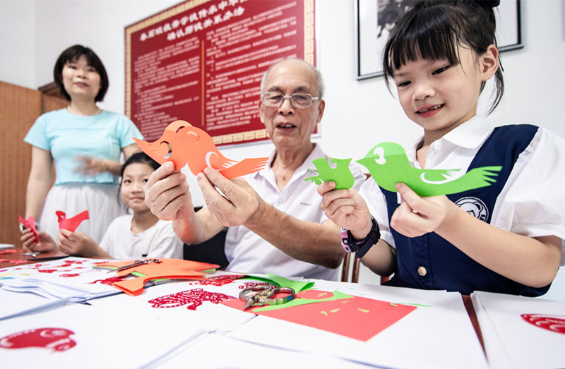 秦石蛟在教小朋友练习剪纸。张奇涛摄