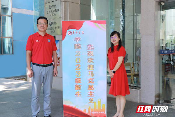马克思主义学院的老师们身着红衣红裙等候新生的到来 摄：王佳妮_副本.jpg