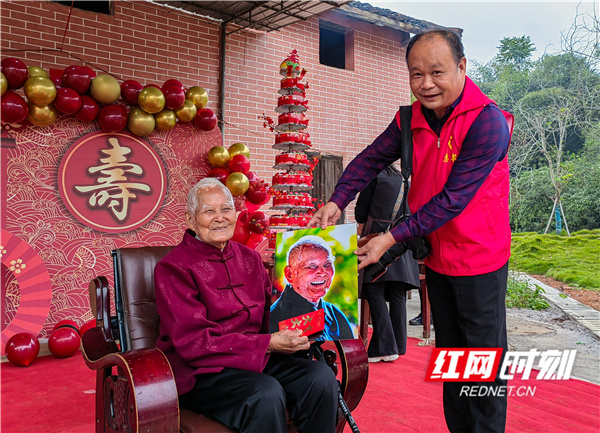 永州市摄影协会副主席、江永县摄影协会主席黄海为百岁老人送来了照片   任泽旺 摄.jpg
