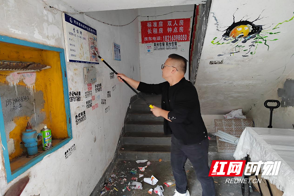退役军人参与环境治理清理楼道内小广告.png