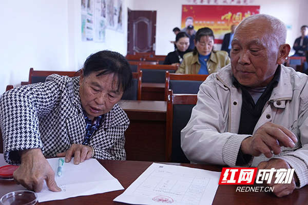 在群众和工作人员见证下雷桂香确认法院裁定书并签字按手印.jpg