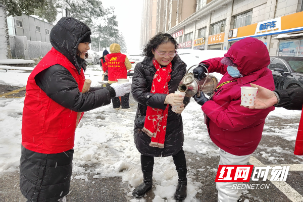 湘龙街道锦元社区恒广国际景园小区楼栋长苏阿姨、田阿姨一大早熬姜茶，为正在铲雪除冰的志愿者们送上热腾腾的姜茶，驱散寒意，传递温暖。.jpg