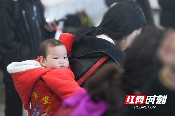 2024年1月30日，在湖南省永州市道县道州站，家长背着小孩子准备检票上车。.jpg