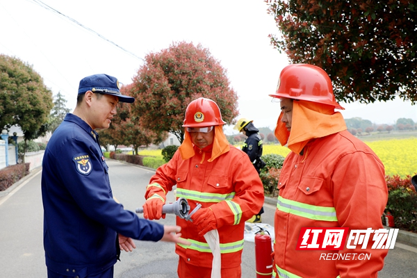 在田间地头为乡村振兴学校参加培训的消防志愿者传授消防水带的理解方法.JPG